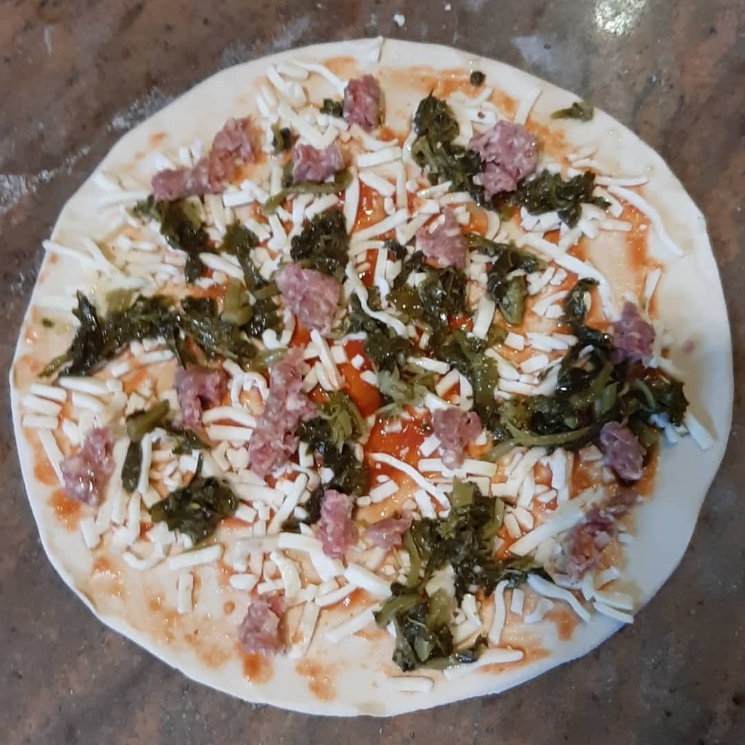 Pizza salsiccia e friarielli in preparazione sul banco