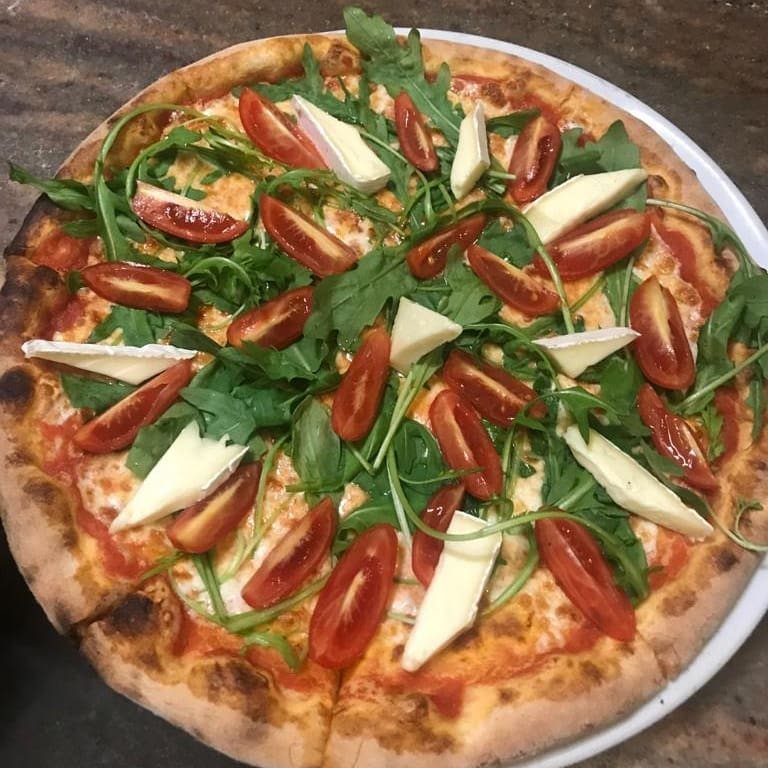 Pizza con rucola, pomodorini e scaglie di grana
